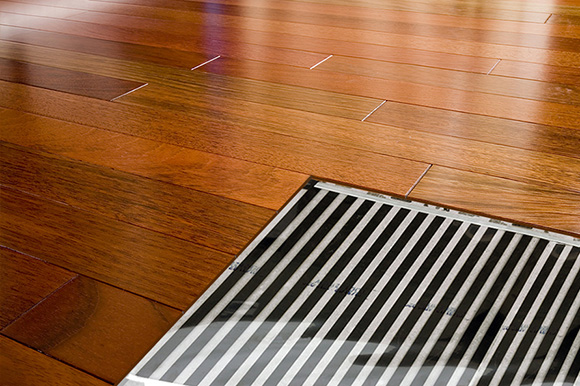 FilmHeat floor heating system shown under heated hardwood floor.
